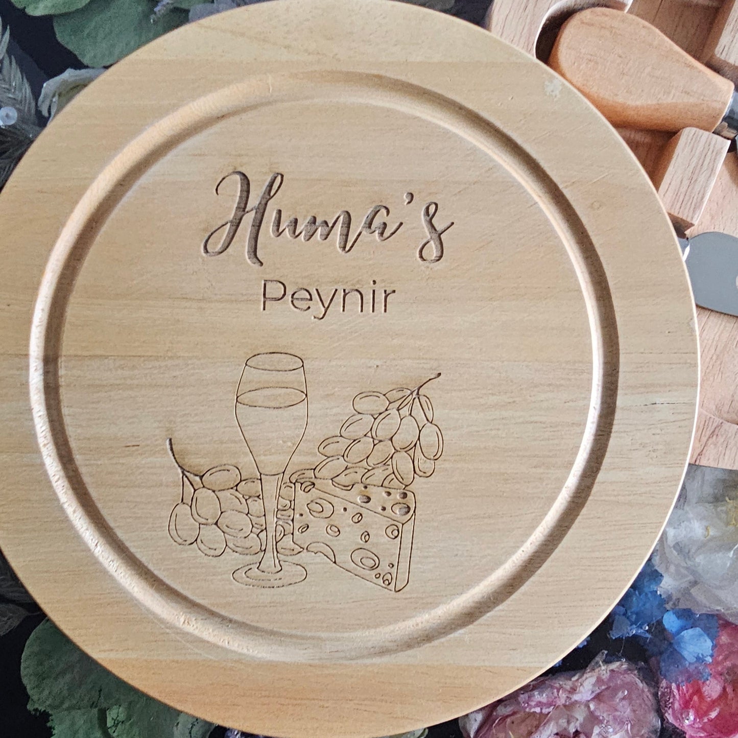 Wooden round tray with engraved design and text on a decorative background