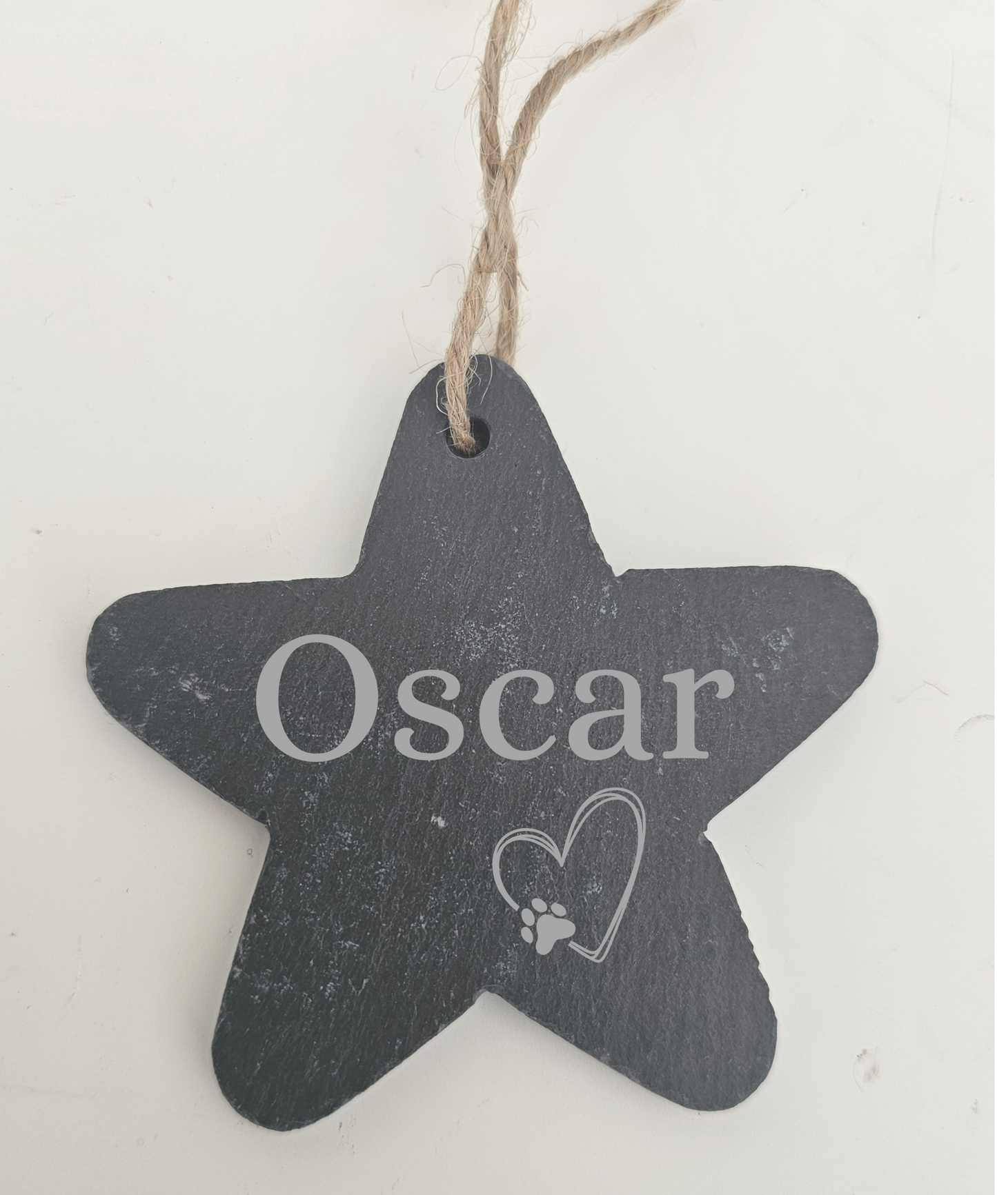 Star-shaped chalkboard tag with 'Oscar' and a heart with a paw print on a white background