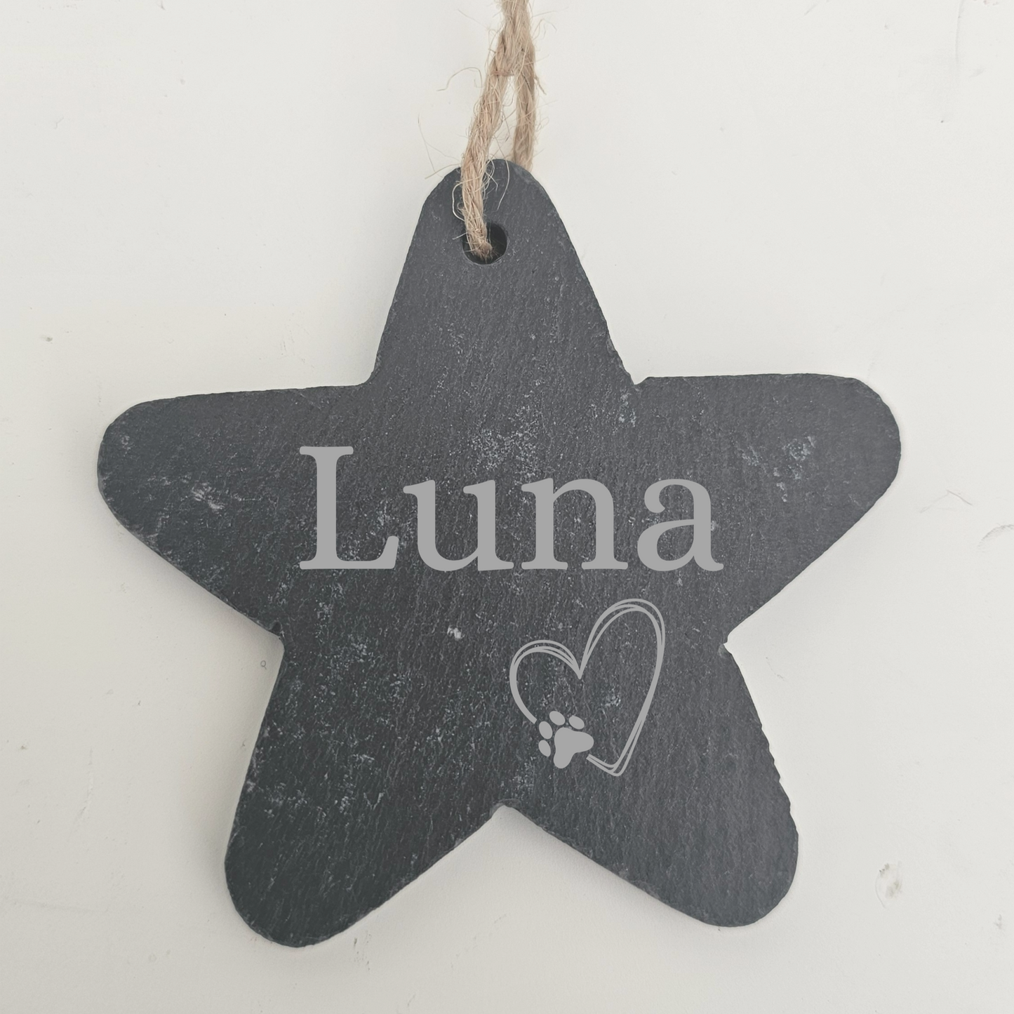 Star-shaped slate sign with 'Luna' and a heart with a paw print on a white background