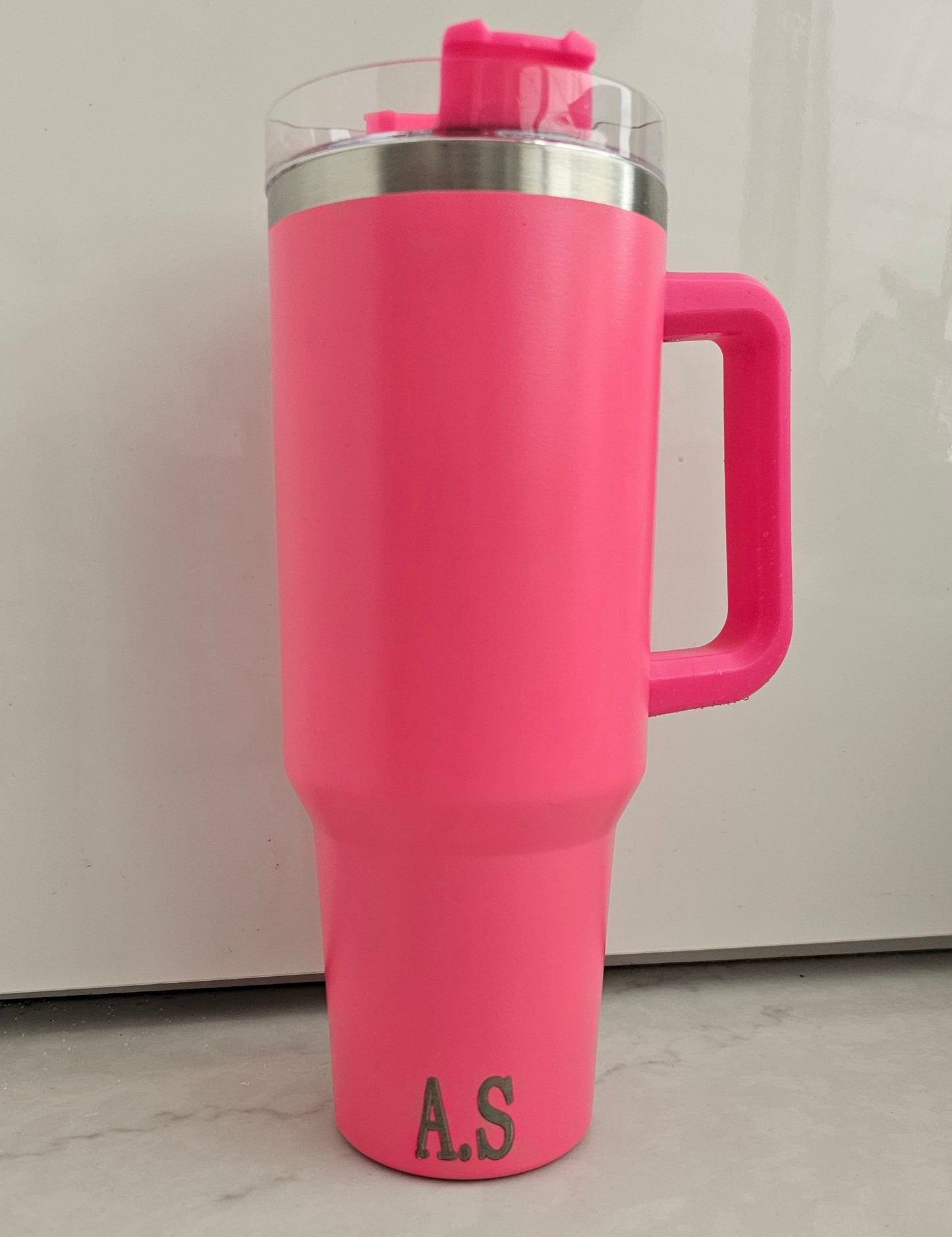 Personalised Pink water bottle with a handle and initials a.s engraved on it on a light gray background