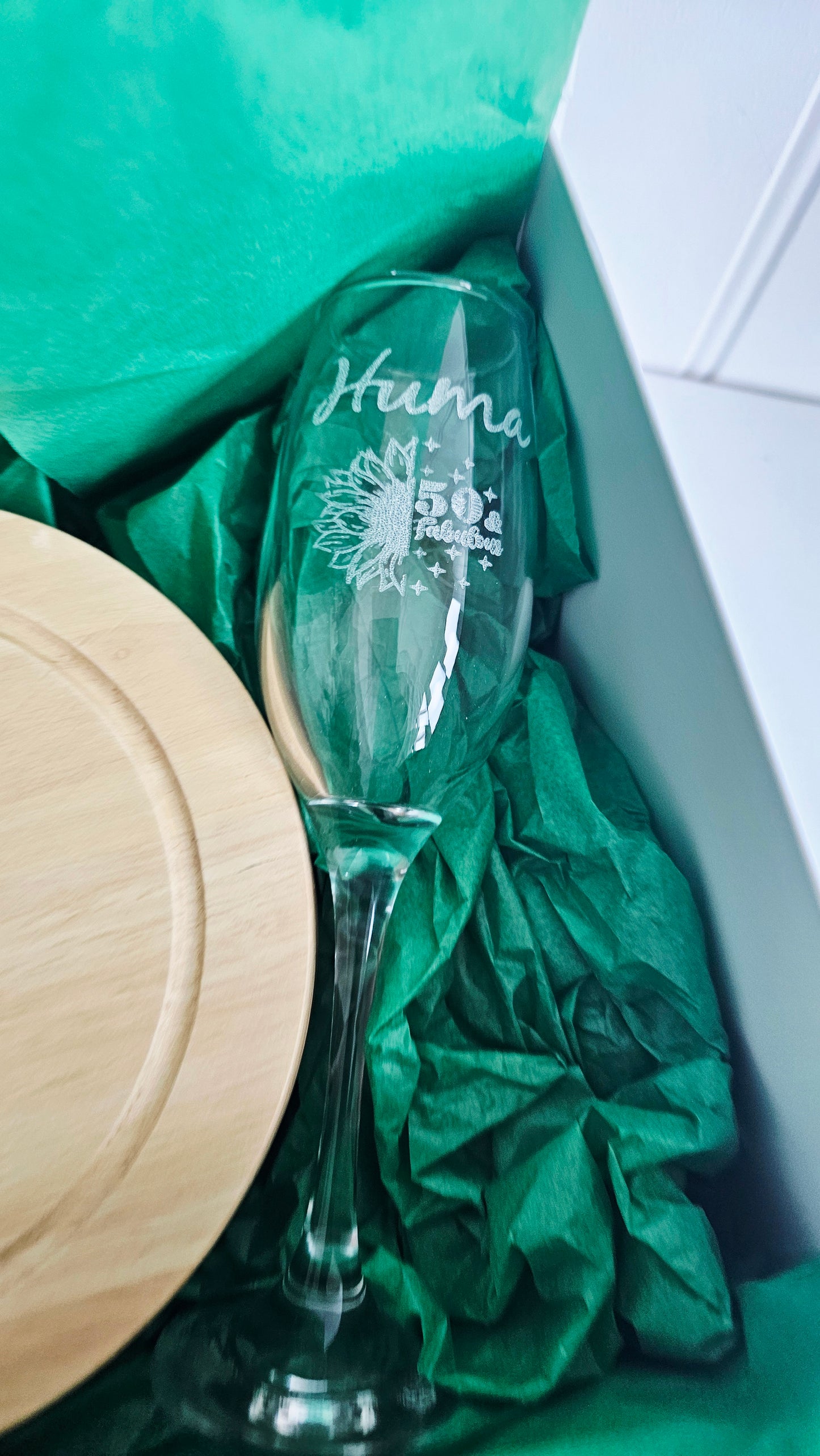Glass with engraved text on green tissue paper