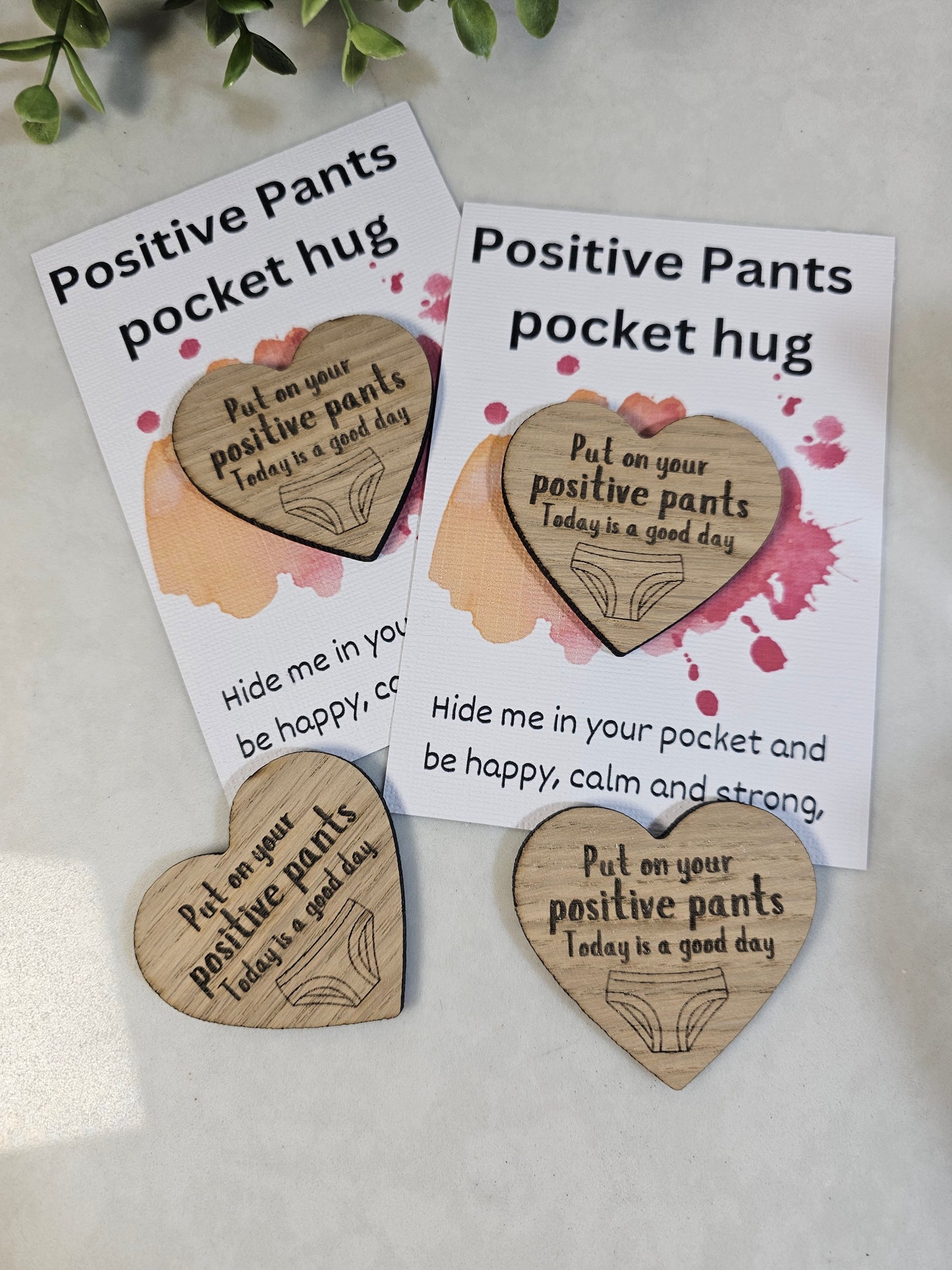 wooden positive pants pocket hugs in a heart shape on a display card