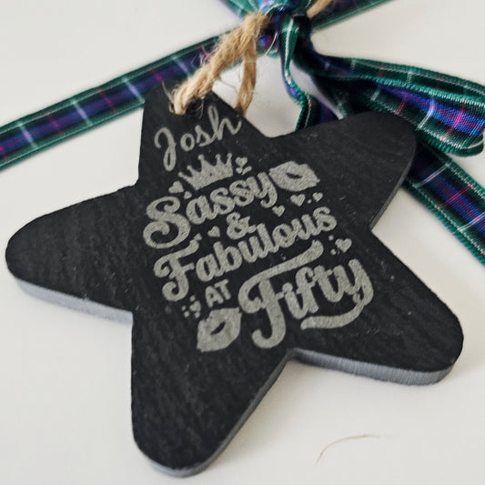 Star-shaped ornament with 'Josh Sassy & Fabulous at Fifty' text on a tartan background