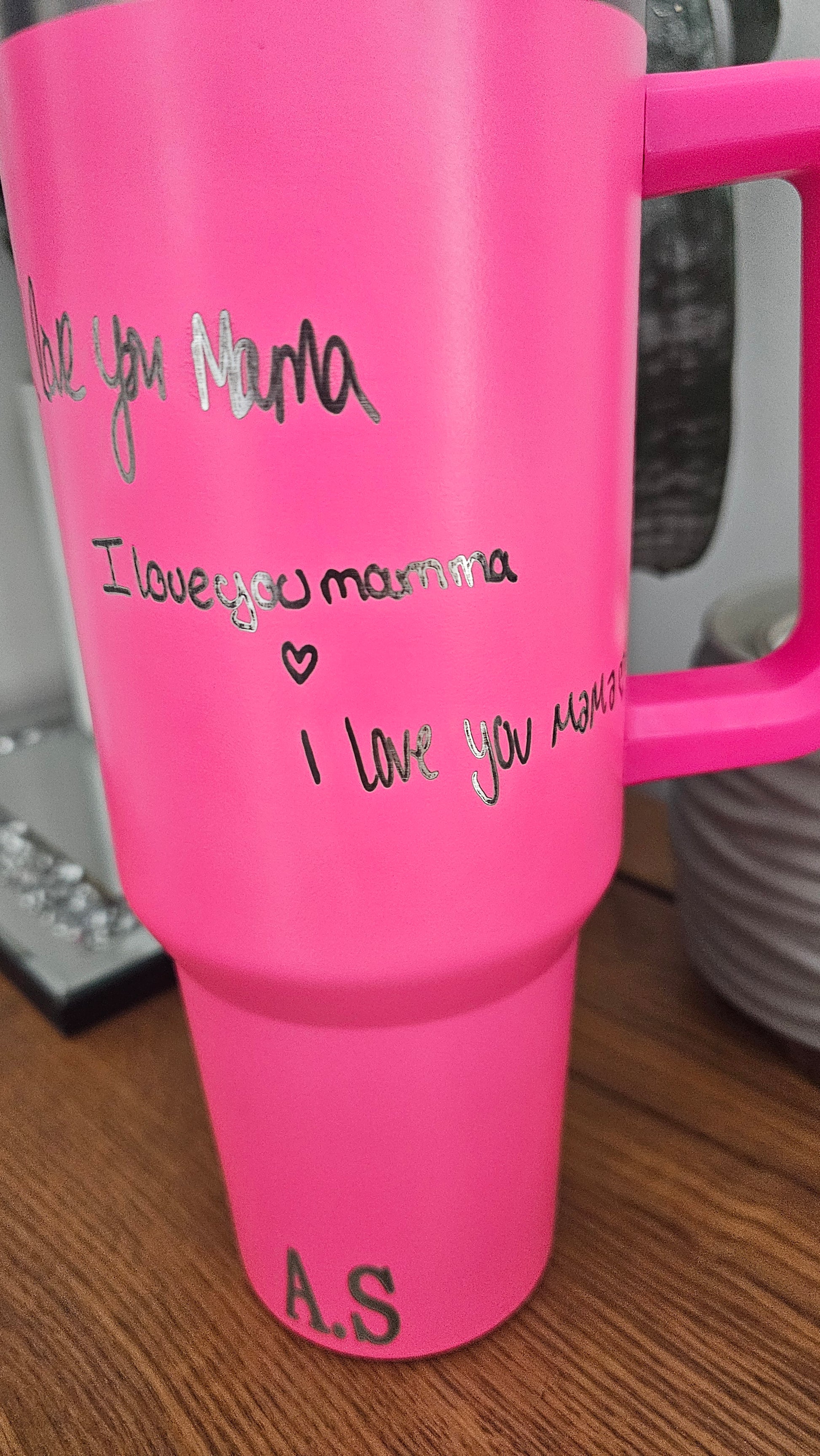 Pink water bottle with text on a wooden surface