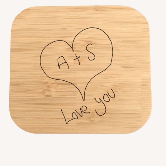 Bamboo wireless charger with 'A+S Love You' engraving on a white background