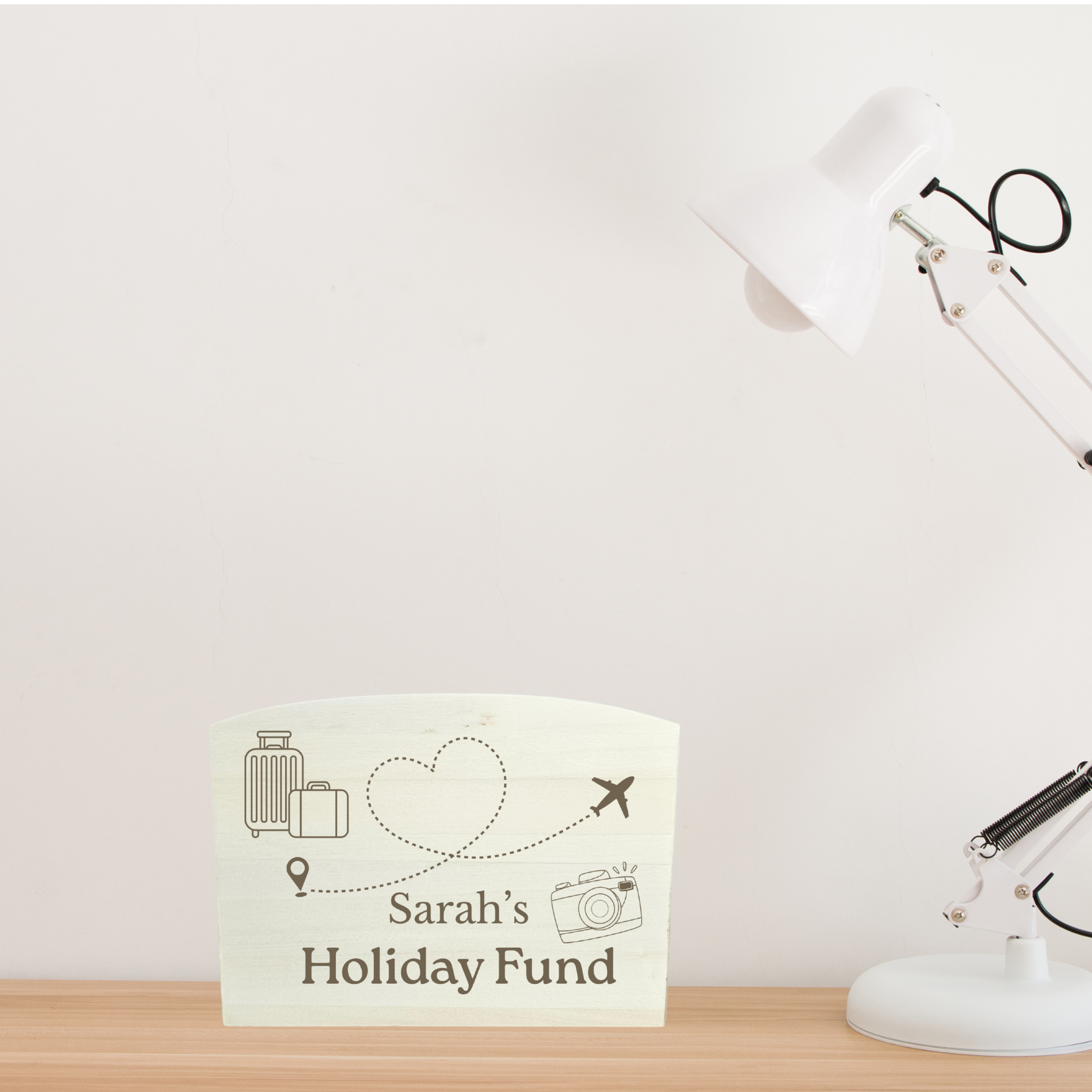 Desk with a lamp and a personalised money box  on a white background