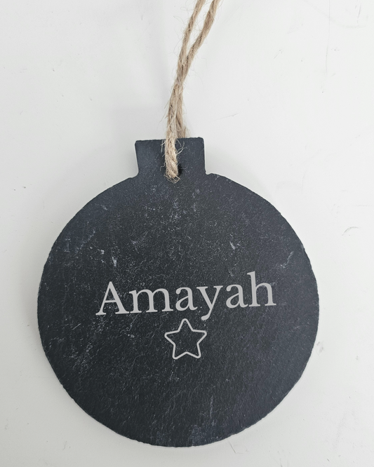 Round slate tag with 'Amayah' and a star, hanging on a string against a white background.