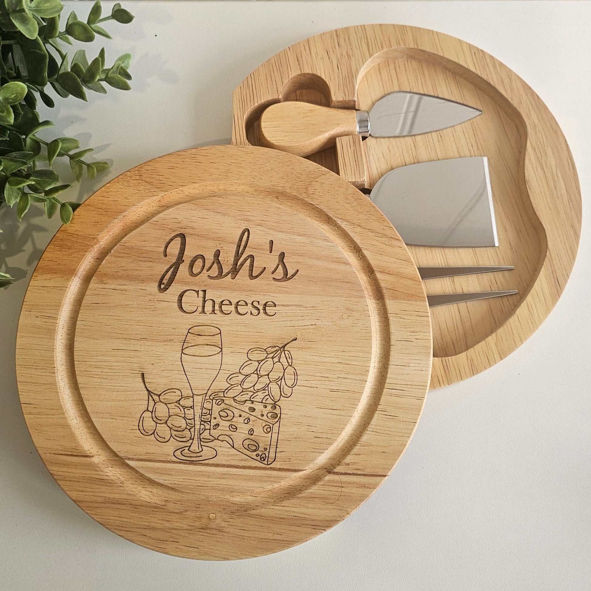 Wooden cheese board set with engraved design and 'Josh's Cheese' text on a light background.