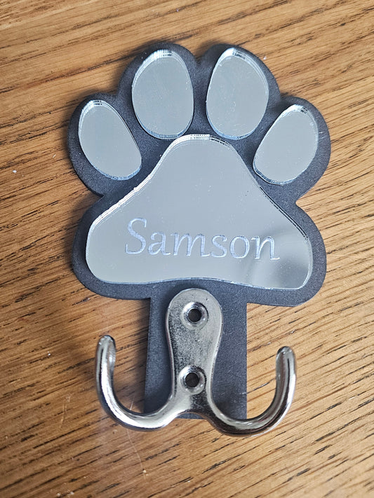 Paw-shaped hook with 'Samson' engraved on a wooden surface