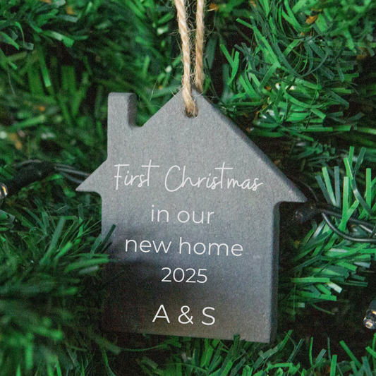 House-shaped ornament with 'First Christmas in our new home 2025 A & S' text on a green background