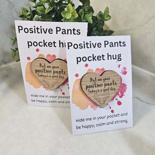 2 display cards with a wooden heart on the from with the engraving positive pants 