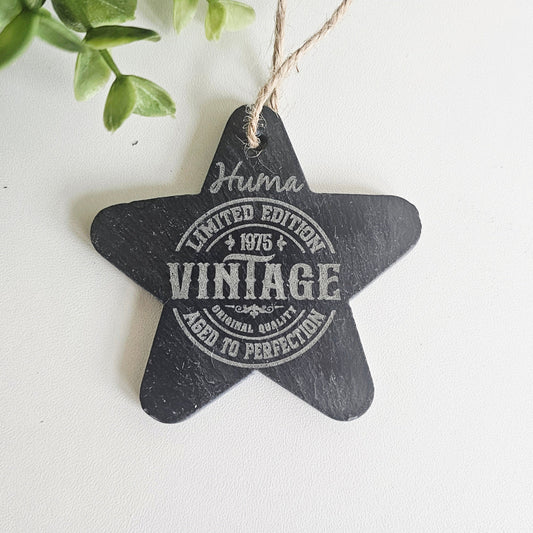 Star-shaped engraved slate ornament with white text on a light background
